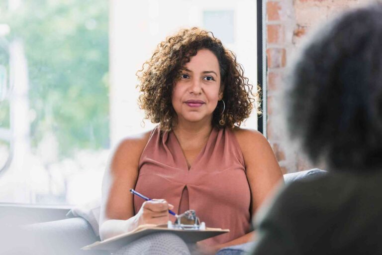 39687c58ed6b4c20fa226c9c4a102bf6-therapist-takes-notes-on-a-clipboard-while-listening-to-her-client_l